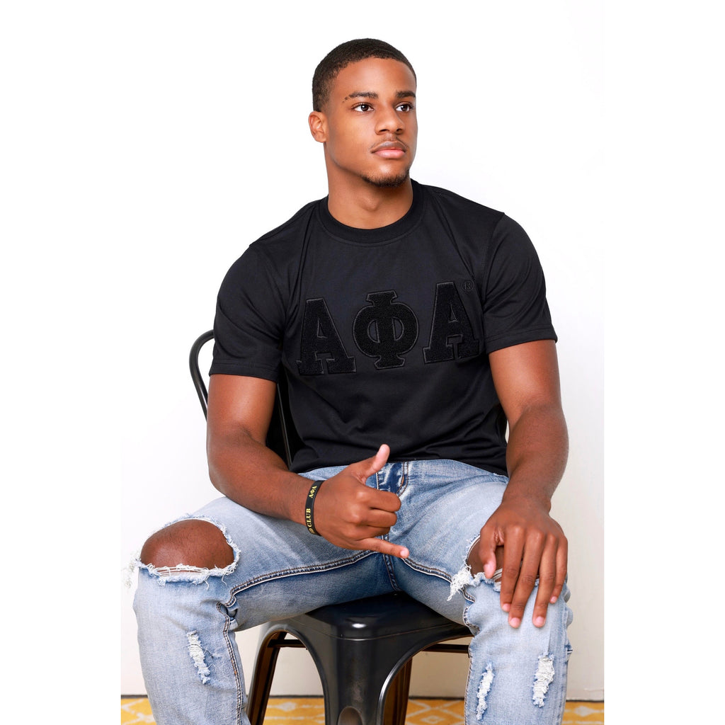 Man in Solid Black ΑΦΑ Chenille Tee: Soft cotton t-shirt featuring an embroidered logo for a durable, high-quality appearance