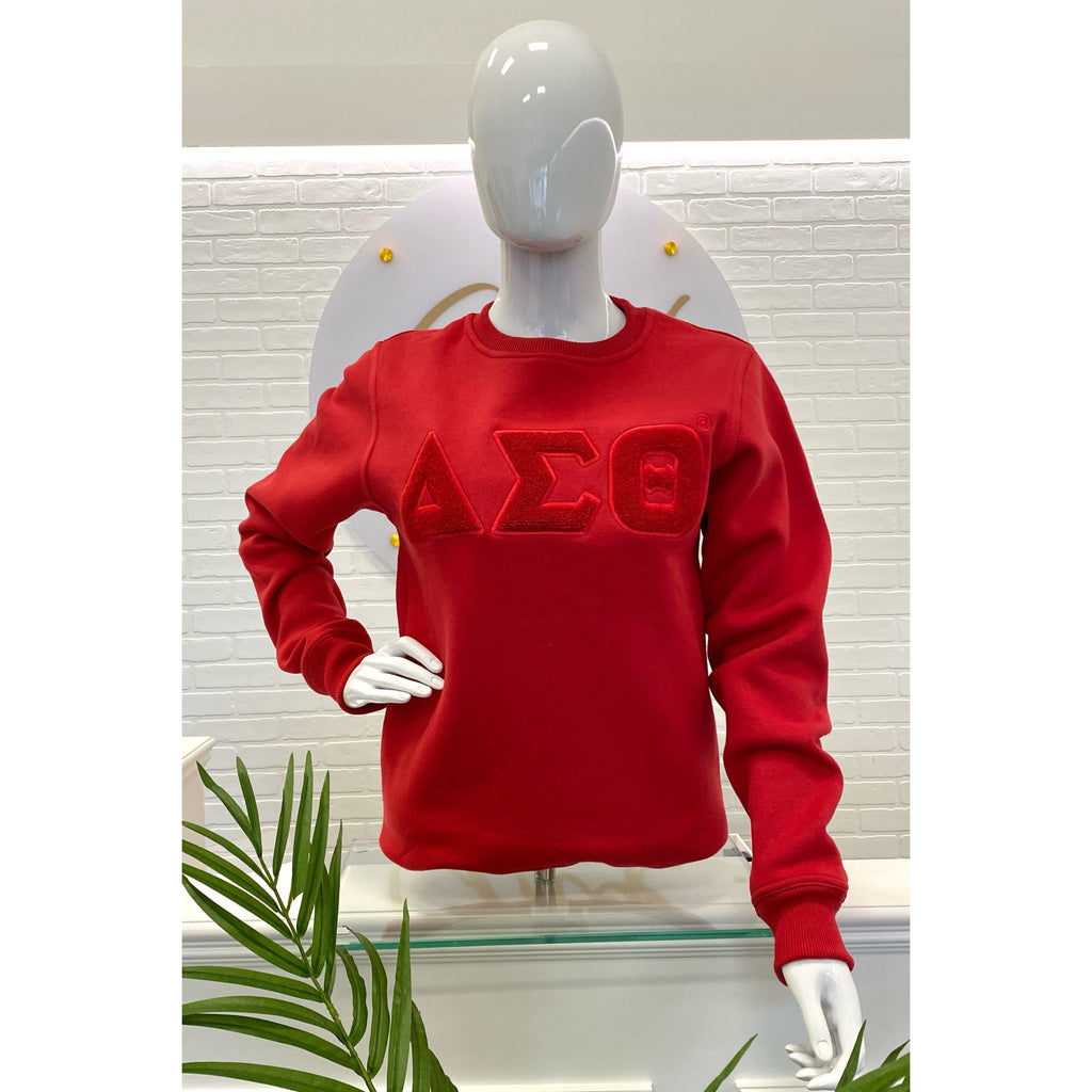 A woman wearing a Red sweatshirt with the letters  ΔΣΘ. Solid ΔΣΘ Chenille Sweatshirt, snugger fit if desired.